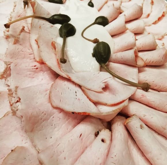 Dünn geschnittene Putenbrustscheiben mit Kapern und Sauce.