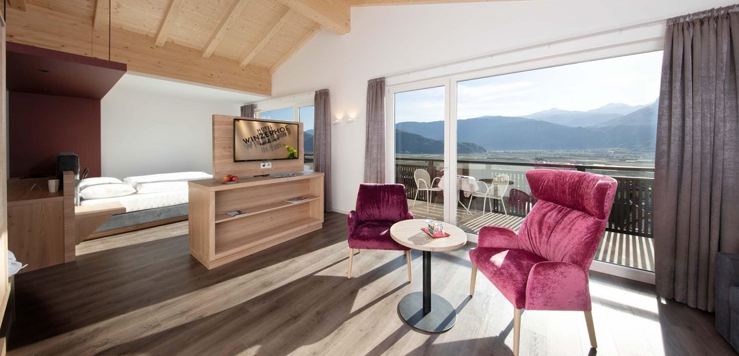Juniorsuite Sitzecke TV Doppelbett Blick auf Südtiroler Etschland