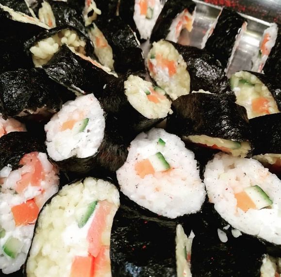 Nahaufnahme von Sushi-Rollen mit Reis, Gurke und Karotte umwickelt mit Seetang.